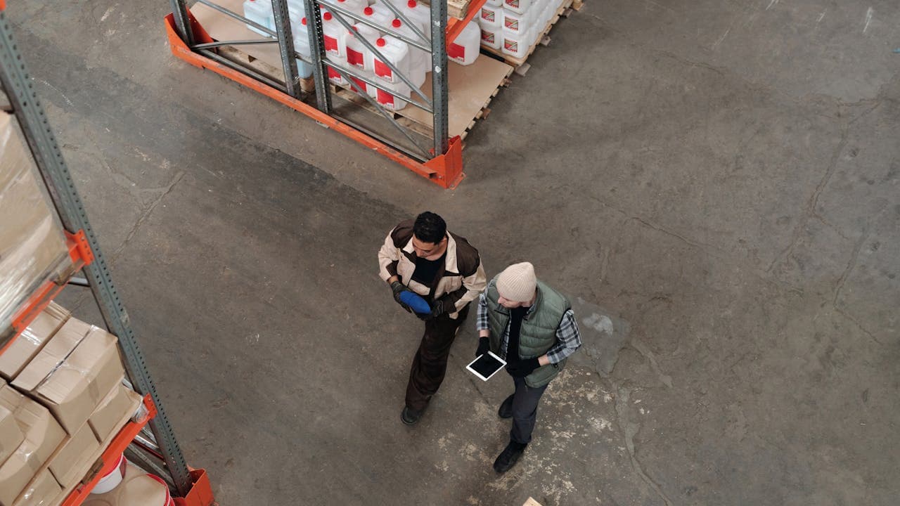 Workers managing stock in a warehouse